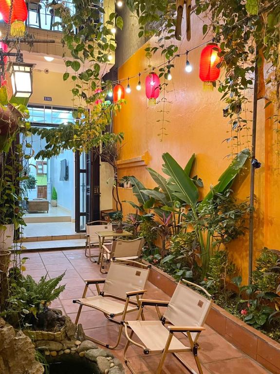 a patio with chairs and plants and lights at The little Ha Noi in Hanoi