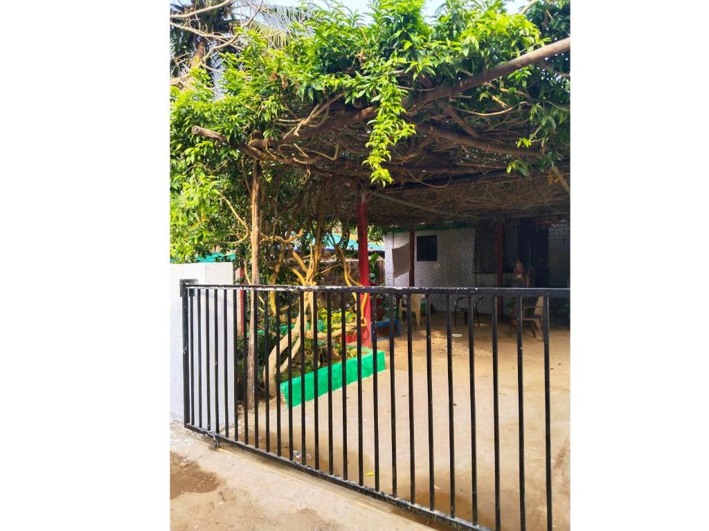 una valla de hierro forjado con un jardín detrás de ella en Cockerel Homestay - Traditional Beach Village - Goa, en Canacona