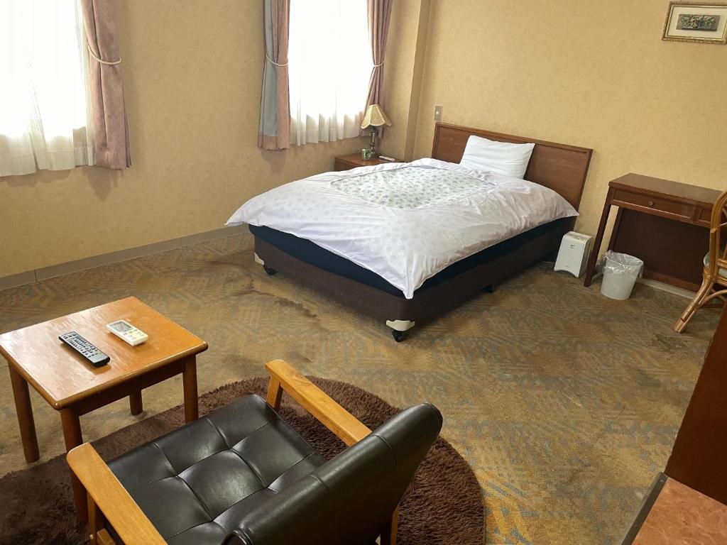 a bedroom with a bed and a couch and a table at Hotel Nissin Kaikan - Vacation STAY 02355v in Shiso