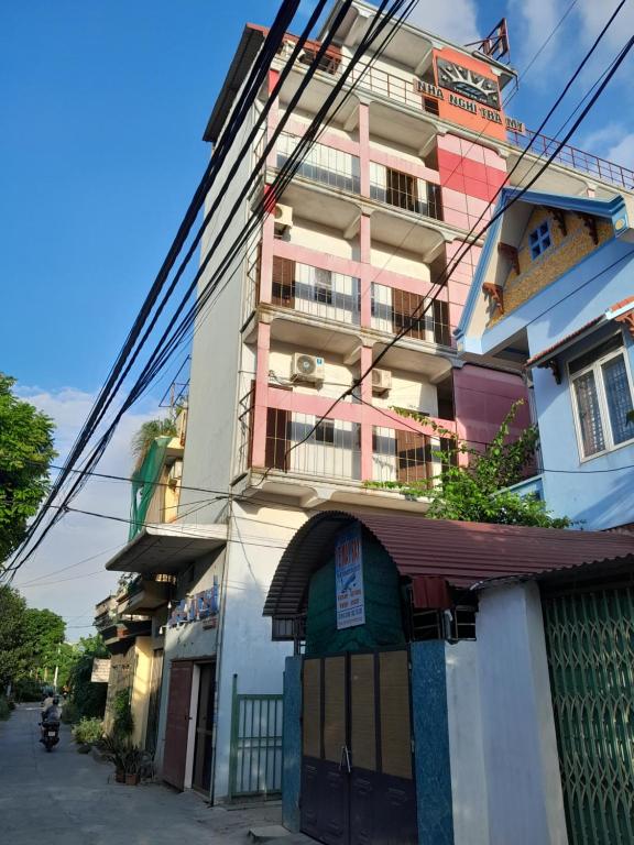 a pink building with a shop in front of it at NHÀ NGHỈ TRÀ MY in Vu Bản