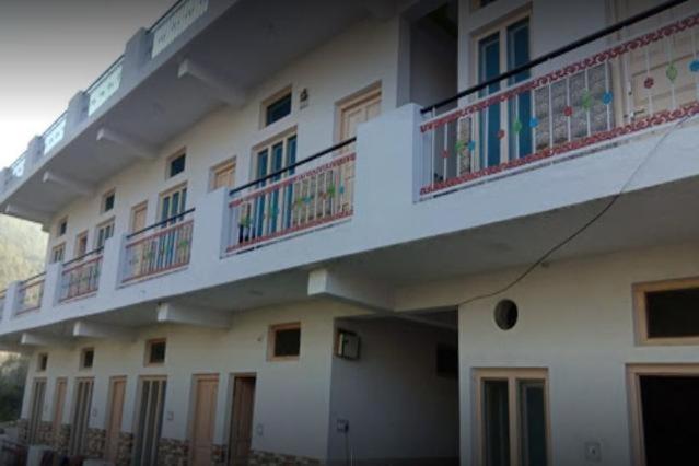 a white building with balconies on the side of it at Vivek Palace by StayApart in Barkot