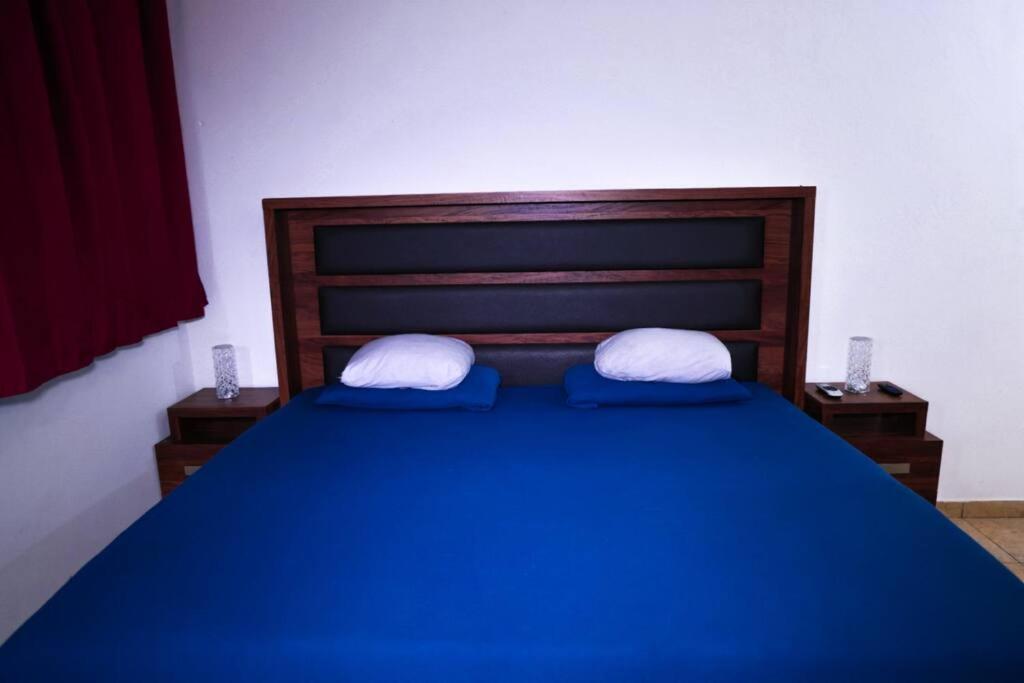 a bedroom with a blue bed with two pillows at In the Romantic Zone one block from the beach! in Puerto Vallarta