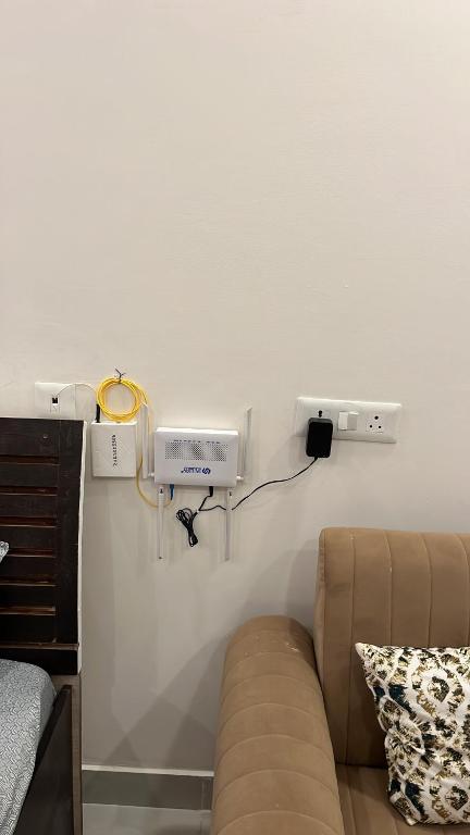 a room with a couch and a heater on a wall at Hello studio in Noida