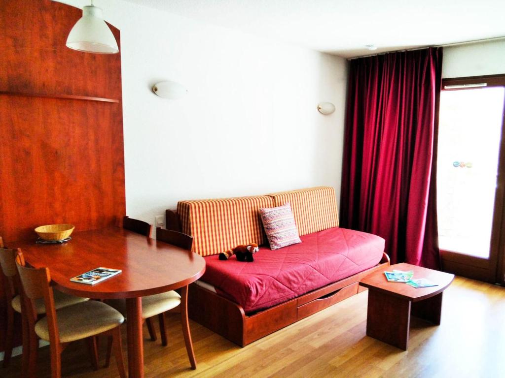 - un salon avec un canapé rouge et une table dans l'établissement Résidence Pic Du Midi - 2 Pièces pour 4 Personnes 074, à La Mongie