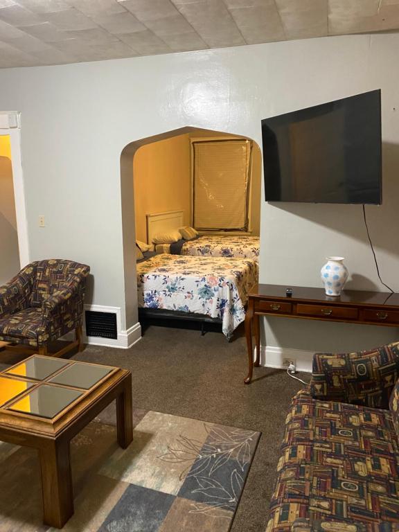 ein Wohnzimmer mit einem Bett und einem Flachbild-TV in der Unterkunft Charming 3 bedroom apartment midtown in Cincinnati