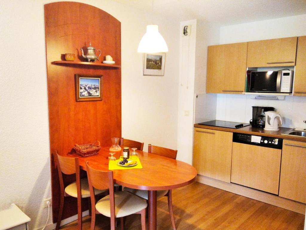 eine kleine Küche mit einem Holztisch in einem Zimmer in der Unterkunft Résidence Pic Du Midi - 2 Pièces pour 4 Personnes 624 in La Mongie