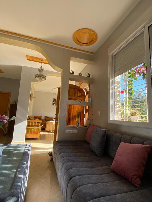 ein Wohnzimmer mit einem Sofa und einem Fenster in der Unterkunft Spacious and Cozy Villa for Peace of Mind, Saidia in Saidia 