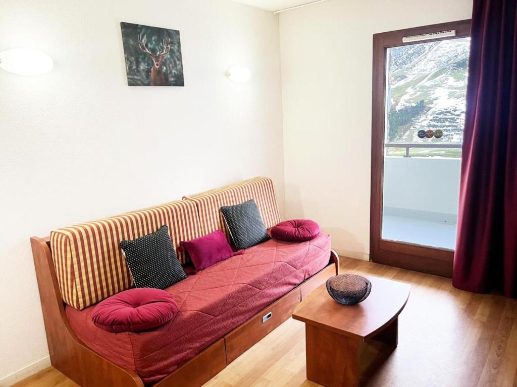 un sofá con almohadas rojas en la sala de estar. en Résidence Pic Du Midi - 2 Pièces pour 4 Personnes 594, en La Mongie