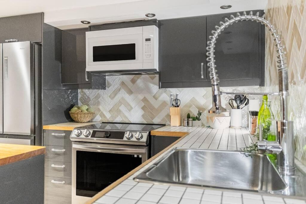 a kitchen with a sink and a microwave at Magnificent 4 1/2 quiet and fully equipped in Montréal
