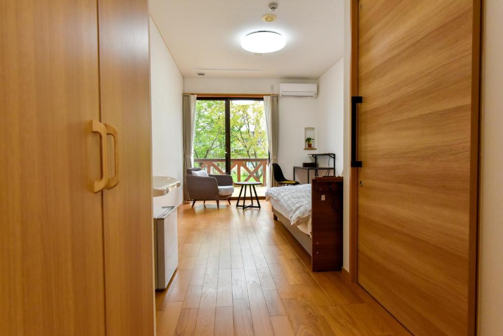 ein Schlafzimmer mit einer Tür, die zu einem Zimmer mit einem Bett führt in der Unterkunft Hotel Circle one in Hitoyoshi