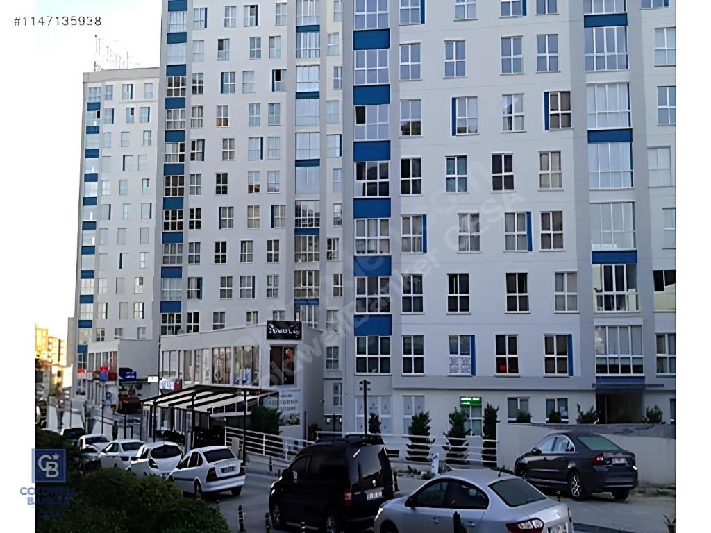 um grande edifício branco com carros estacionados num parque de estacionamento em İNCİ HOUSE em Kırac