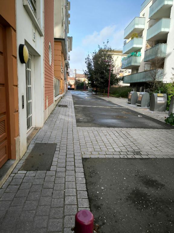 une rue vide avec des bâtiments et une bouche d'incendie rouge dans l'établissement Au coin du souffle 3 pièces au pied du Tram T2, à Bezons