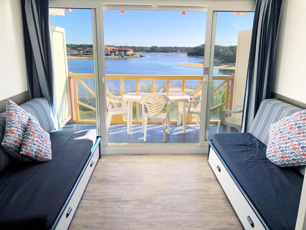 d'un balcon avec une table et une vue sur l'eau. dans l'établissement Résidence Le Boucanier - 2 Pièces pour 4 Personnes 084, à Vieux-Boucau-les-Bains