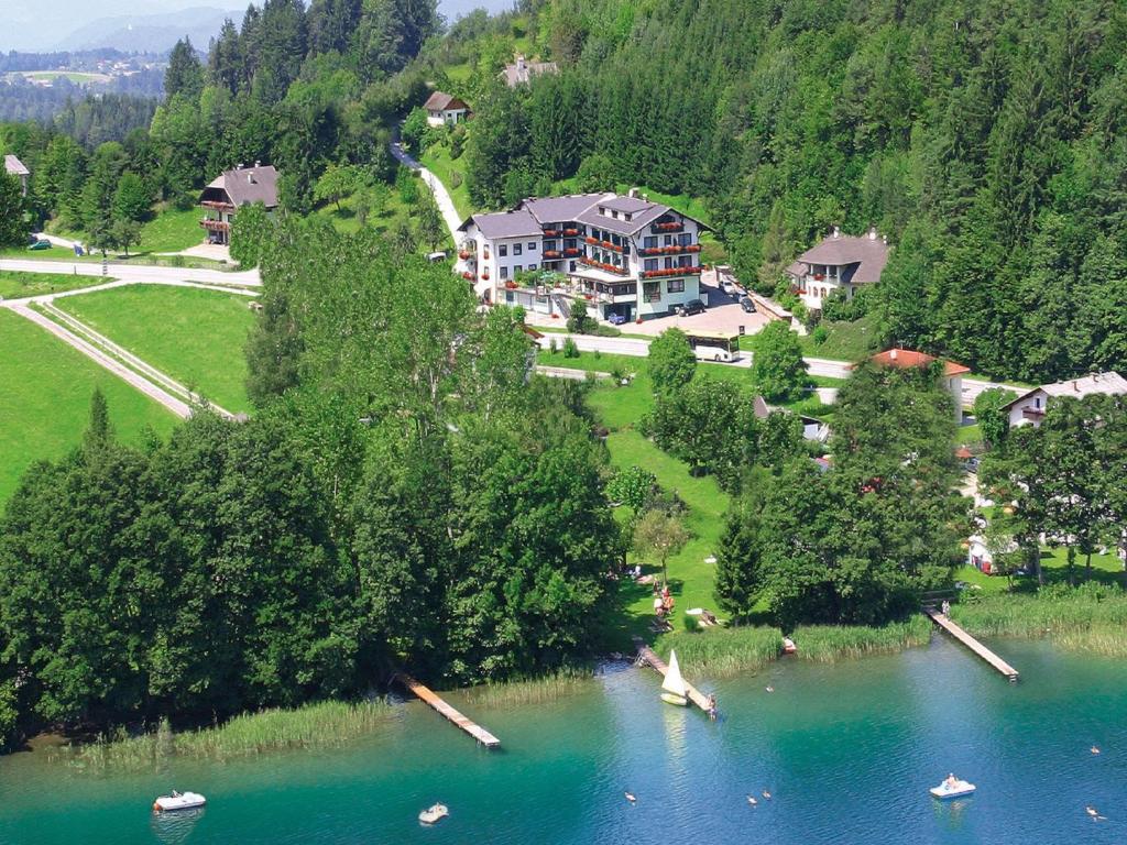- une vue aérienne sur une maison au bord d'un lac dans l'établissement Hotel Ferienwohnungen Gabriel, à Keutschach am See