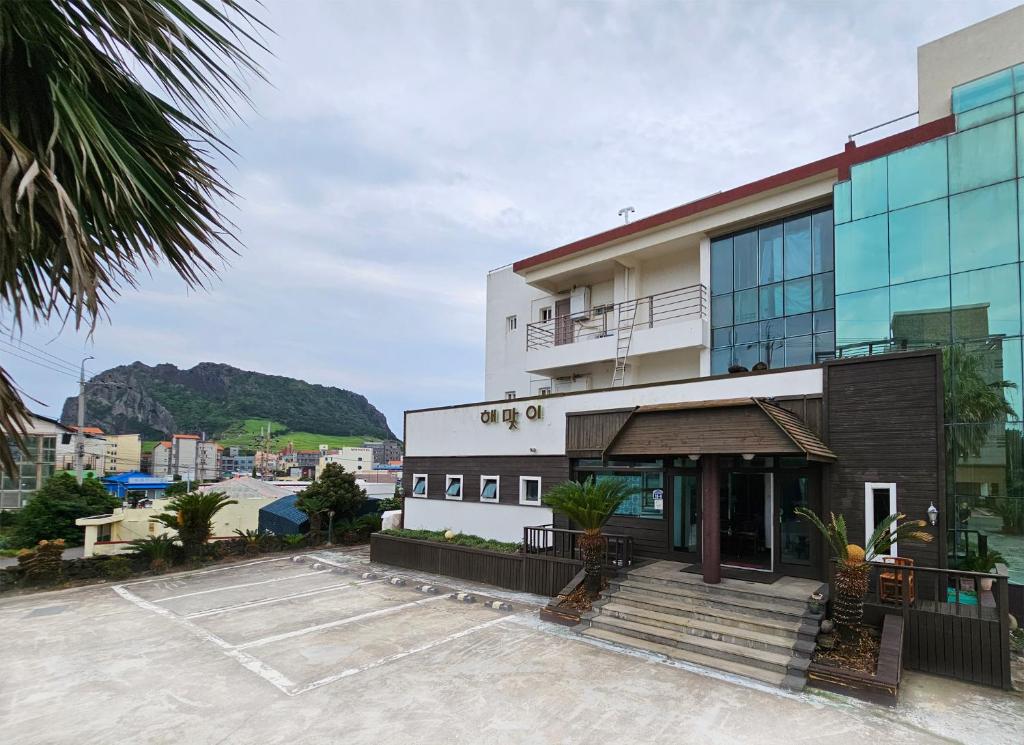 a building with a parking lot in front of it at Seongsan Sunrise Pension in Seogwipo