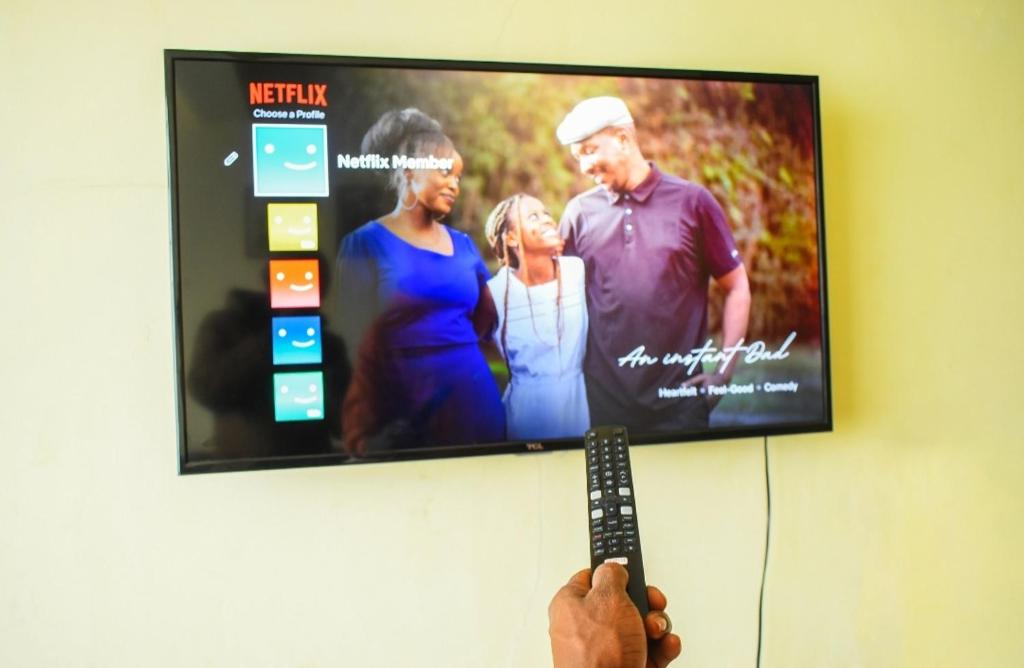 una persona que tiene un mando a distancia frente a un televisor en The escape, nyahururu., en Nyahururu