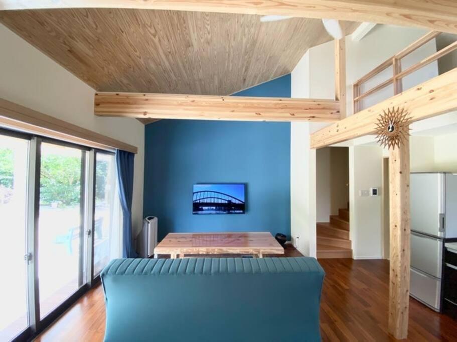 Fukai的住宿－米原ビーチステイLUANA，一间拥有蓝色墙壁的卧室和一张高架床