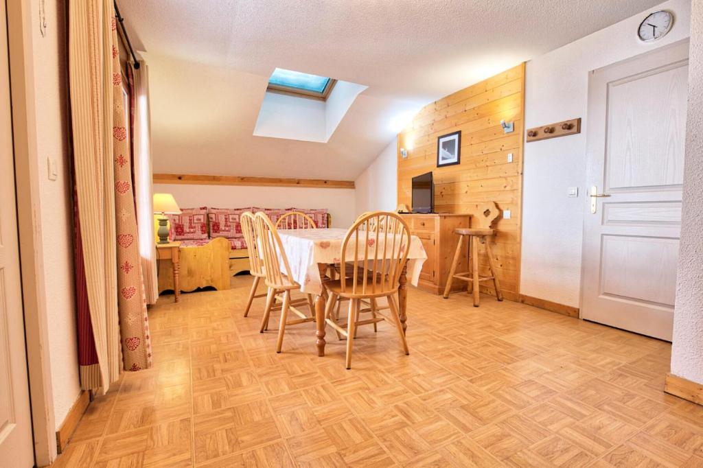 a kitchen and dining room with a table and chairs at Les Chalets Des Evettes - 3 Pièces pour 6 Personnes 04 in Notre-Dame-de-Bellecombe