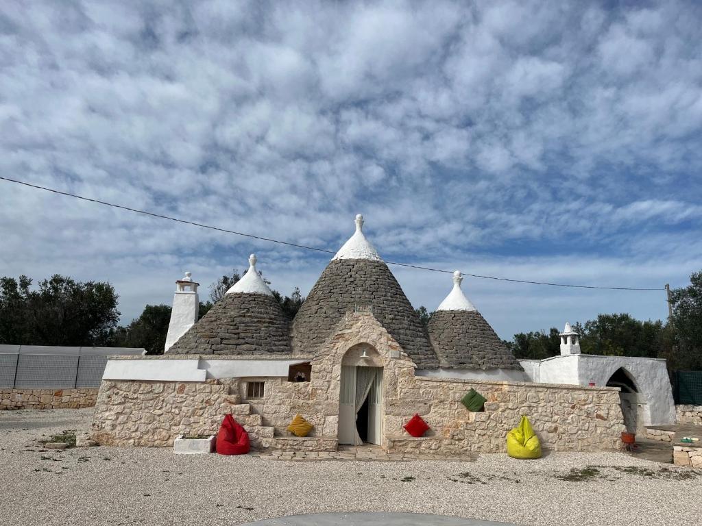 un pequeño edificio de piedra con techo con objetos coloridos en Anglica's Suite, en San Michele Salentino