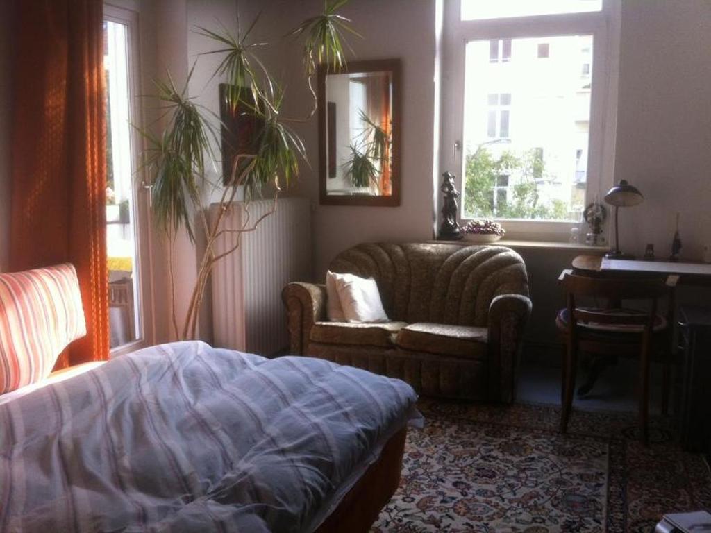 een woonkamer met een bank en een stoel bij Privatzimmer Wagner in Hannover