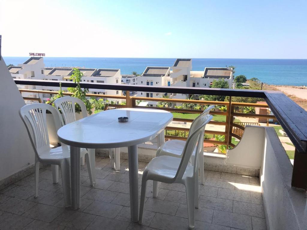 a white table and chairs on a balcony with the ocean at Solemar resort, Kaslik, all Fees are included Generator, electricity, wifi,etc in Al Kaslīk