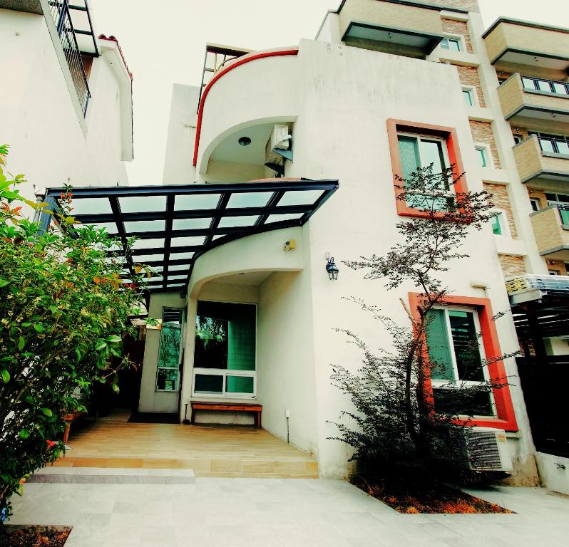 um edifício branco com uma escada que conduz a uma porta em 輕旅小站 Soft Travel Hostel em Taitung City