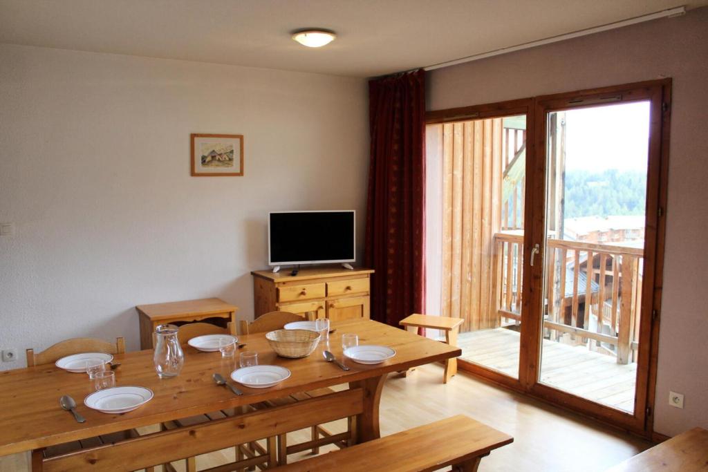 a dining room with a table and a television at Les Chalets De Superd Ancolie - 3 Pièces pour 10 Personnes 324 in Le Dévoluy