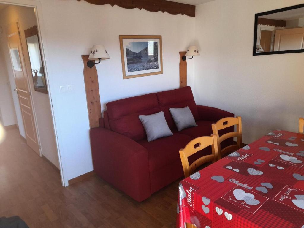 un salon avec un canapé rouge et une table dans l'établissement Résidence Bartavelle Crete Du Berger - 2 Pièces pour 6 Personnes MAE-8534, à Saint-Étienne-en-Dévoluy