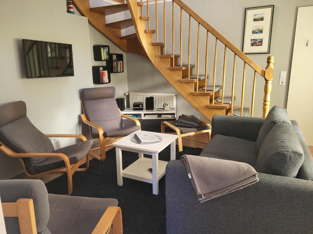 a living room with two chairs and a staircase at Nörderland in Norden
