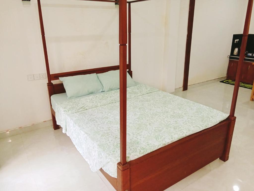 希卡杜瓦的住宿－New Summer Vacation，一间卧室配有一张四柱床。