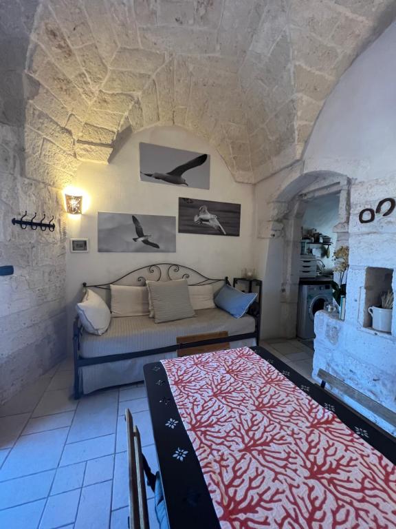 een woonkamer met een bank en een bed bij La Maison di Paola in Ostuni