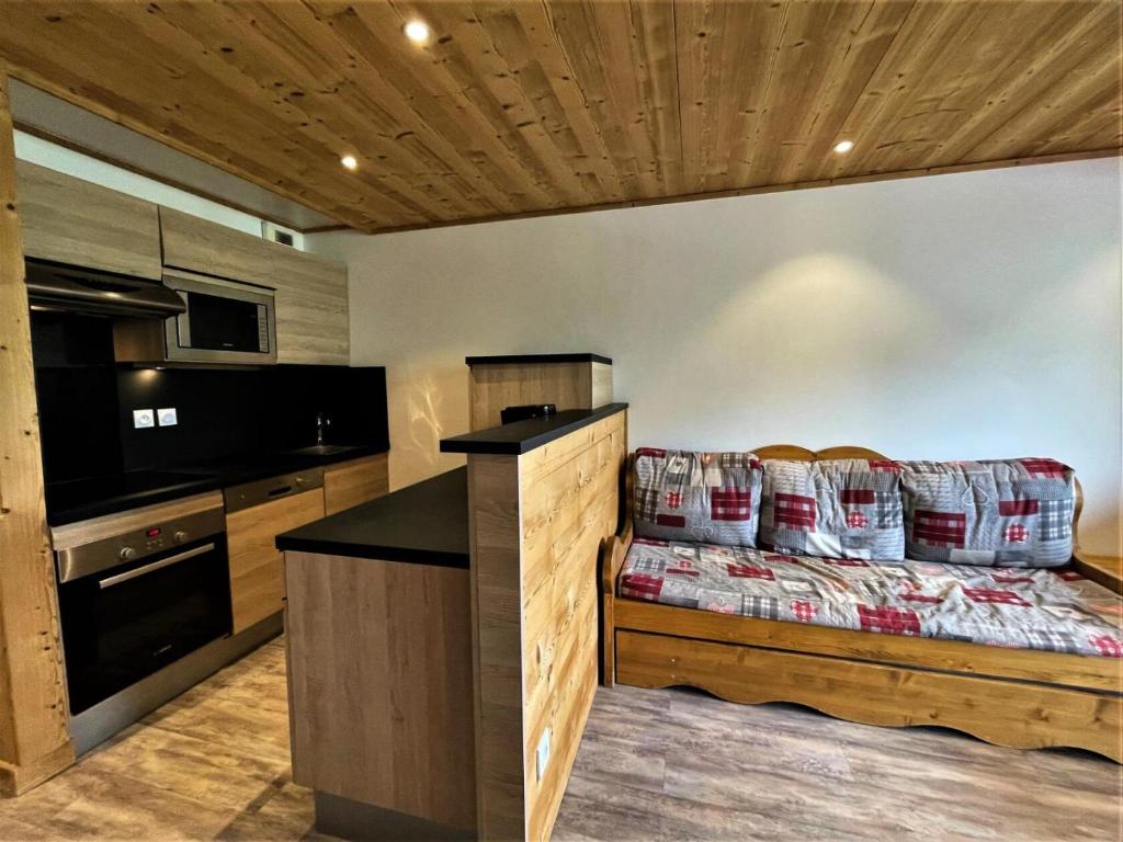 een woonkamer met een bank en een keuken bij Résidence Courmayeur - 2 Pièces pour 4 Personnes 934 in Les Menuires