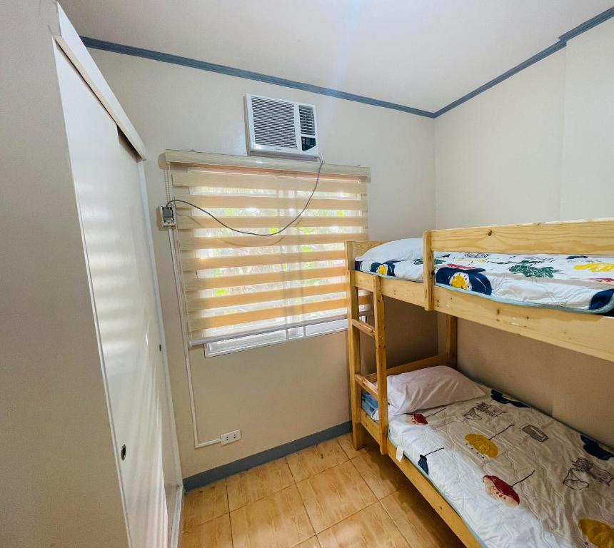 - une chambre avec 2 lits superposés et une fenêtre dans l'établissement Madie's Apartelle near EK & Laguna Technopark, à Santa Rosa