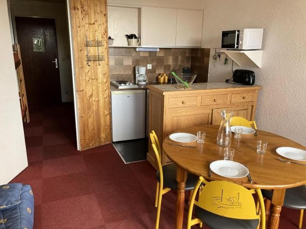 a kitchen with a wooden table and yellow chairs at Résidence Rond-Point-pistes I - Studio pour 4 Personnes 054 in Orcières