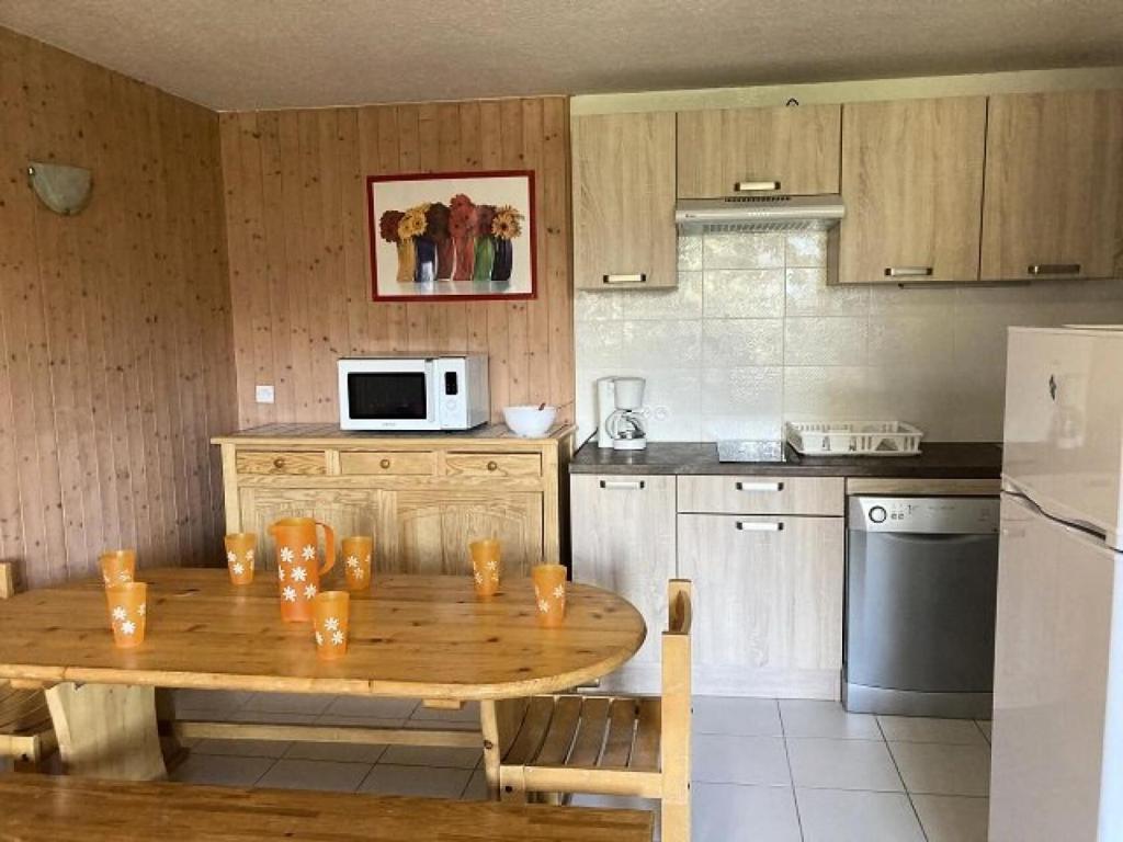 - une cuisine avec une table en bois dans l'établissement Résidence Rond-point-pistes I - Deux pièces 8 pers le ROND POINT DES PISTES 1 n °131 A MAE-7194, à Orcières