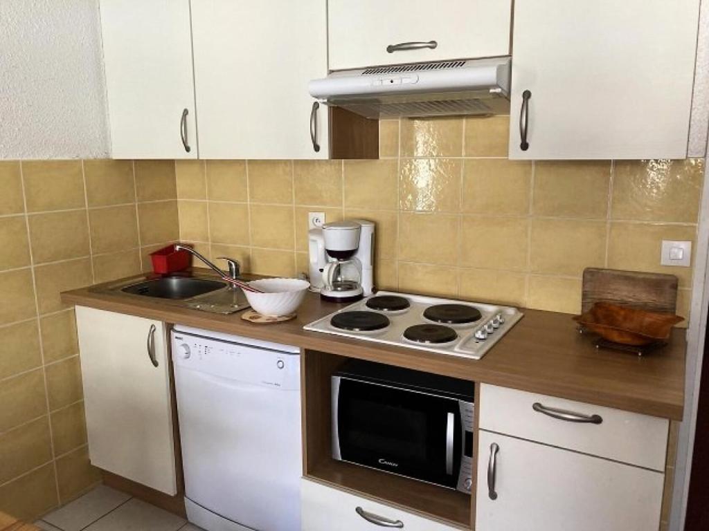 a kitchen with a stove and a sink at Résidence Rond-Point-pistes I - 2 Pièces pour 8 Personnes 244 in Orcières