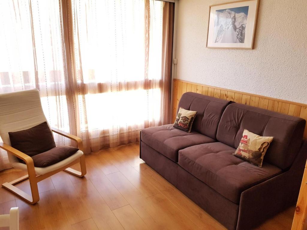 un salon avec un canapé et une chaise dans l'établissement Résidence Challe - Joli studio 4 personnes ski au pied et vue sur les pistes. MAE-4254, aux Menuires