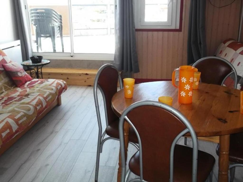 a table and chairs with orange cups on top of it at Résidence Rond-Point-pistes I - Studio pour 6 Personnes 044 in Orcières