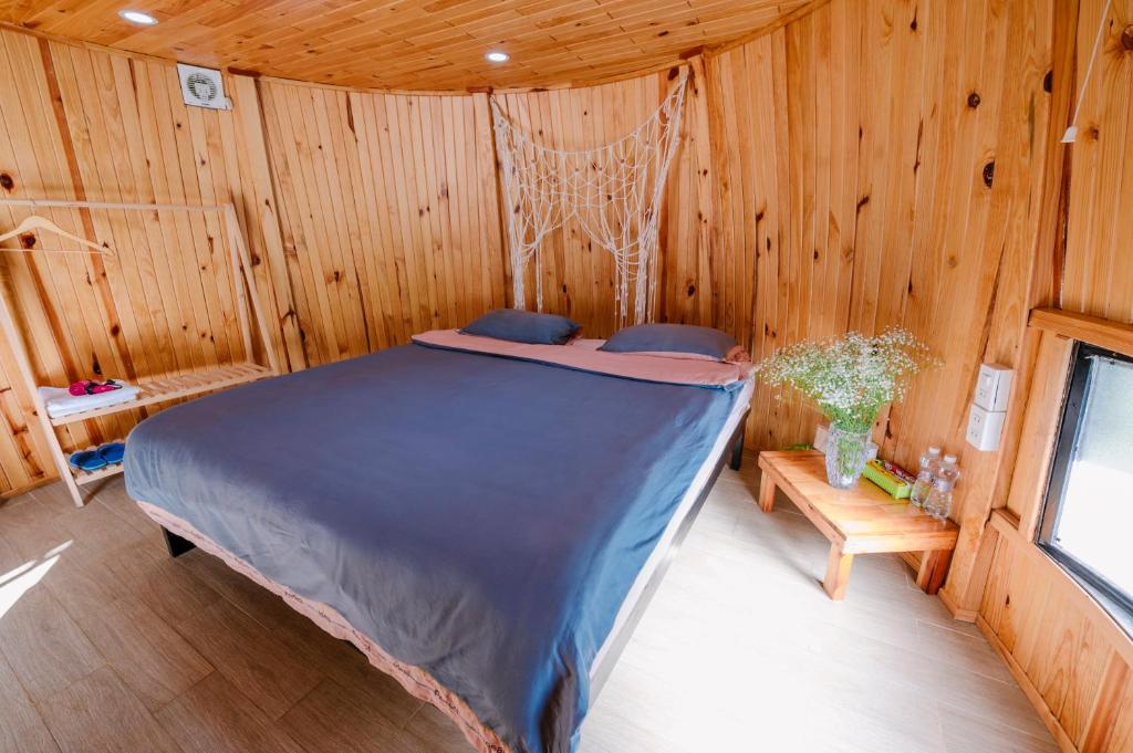 Xuan An的住宿－Wine Valley Homestay Dalat，木制客房内的一间卧室,配有一张床