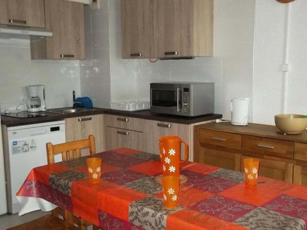- une cuisine avec une table et un four micro-ondes dans l'établissement Résidence Rond-point-pistes I - Trois pièces 8 pers. n°47A au rond point des pistes 1 MAE-7254, à Orcières
