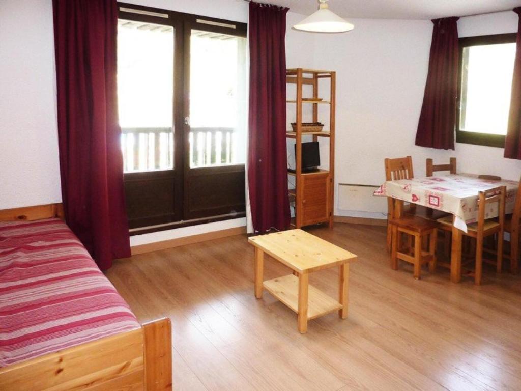 Un dormitorio con una cama, una mesa y un escritorio. en Résidence Orr Des Cimes - STUDIO SUR LES PISTES MAE-0554, en Les Orres