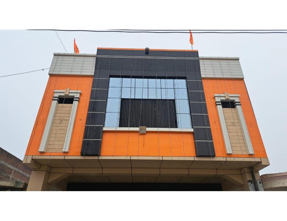 un edificio naranja y negro con dos ventanas en Kanha Guest House, Ayodhya, en Faizābād