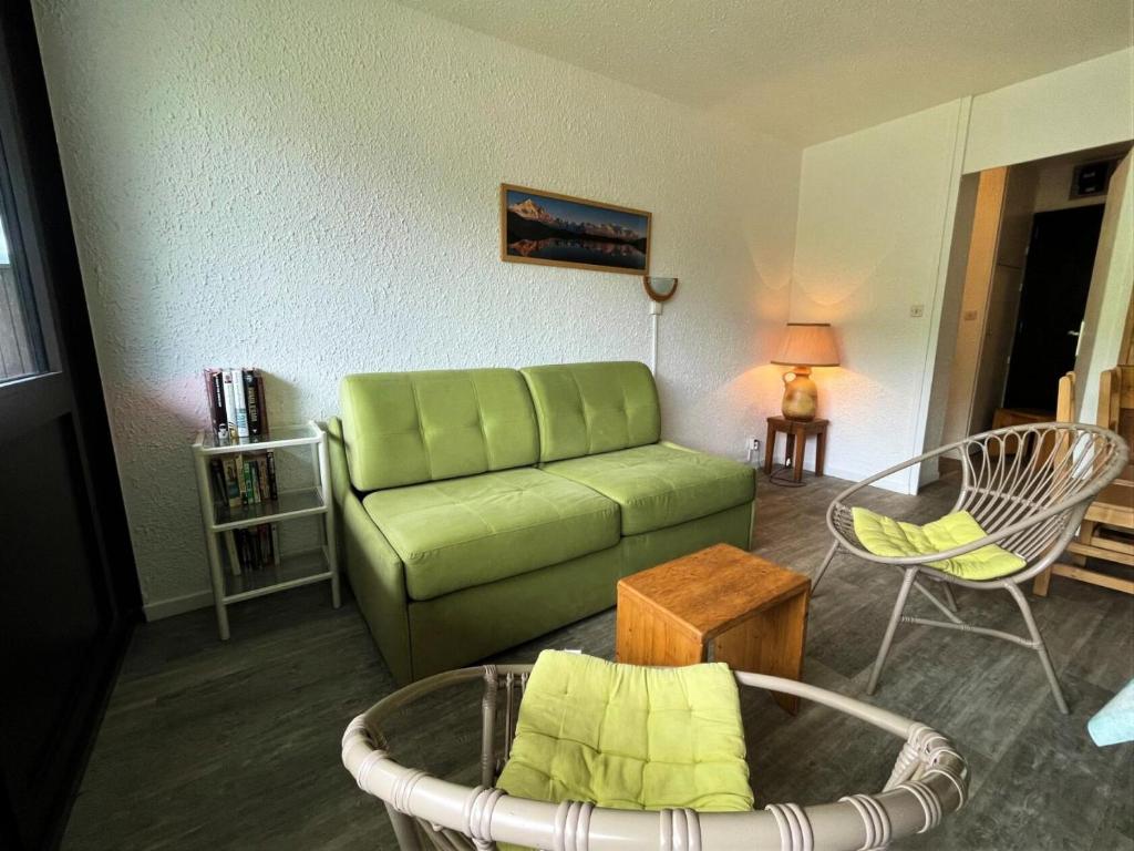 un salon avec un canapé vert et une table dans l'établissement Résidence Aravis - Appartement 6 pers station des 3 Vallées MAE-4834, aux Menuires
