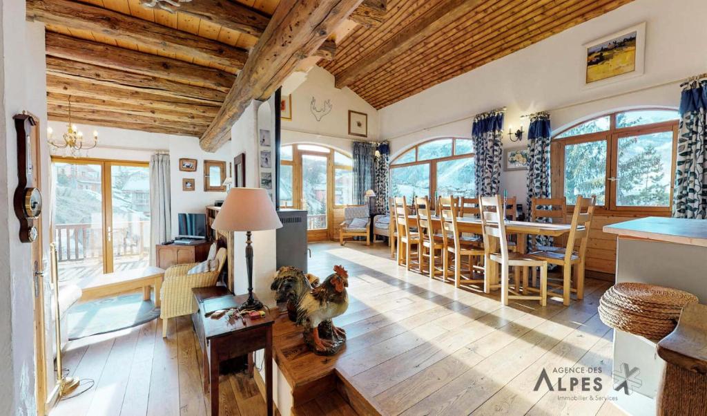 Il comprend un salon doté de plafonds en bois et une salle à manger. dans l'établissement Résidence Balcons De St Martin - Beau chalet 10 personnes dans St Martin De Belleville MAE-4344, à Saint-Martin-de-Belleville