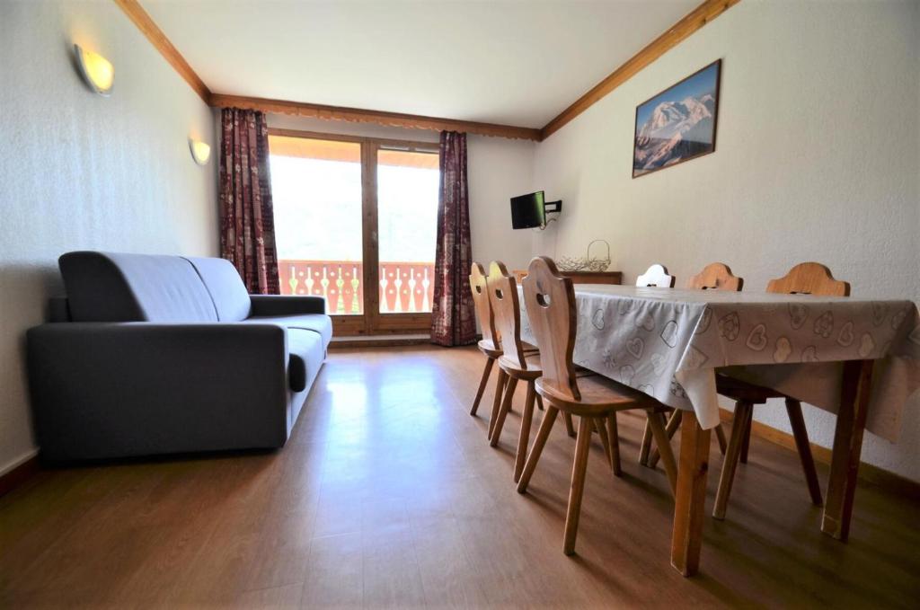 un soggiorno con tavolo, sedie e divano di Résidence Valmont - Appartement 8 pers de 65m2 ski aux pieds MAE-4414 a Les Menuires