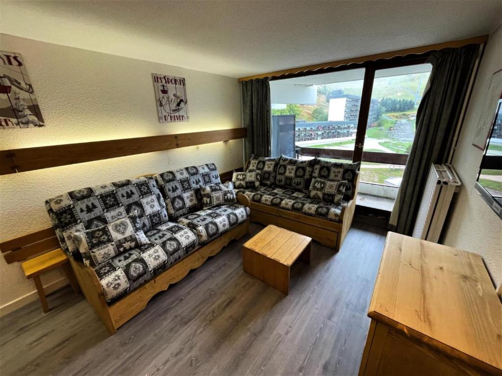 - un salon avec des canapés et une grande fenêtre dans l'établissement Résidence Chaviere - Appartement traversant pour 5 personnes MAE-4984, aux Menuires