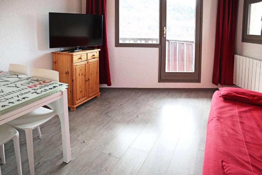 un salon avec une table et une télévision dans l'établissement Résidence Le Cairn - Studio 6 personnes 1650 MAE-1914, aux Orres