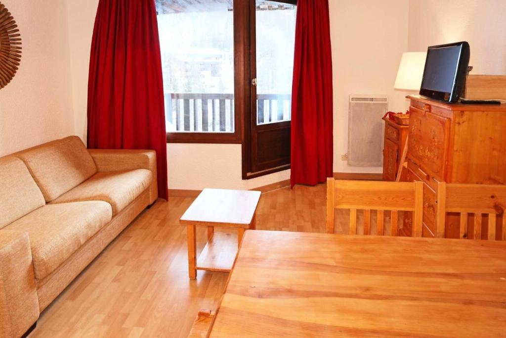 - un salon avec un canapé et des rideaux rouges dans l'établissement Résidence Orr Des Cimes - ORRIANES DES CIMES 512 MAE-4534, aux Orres