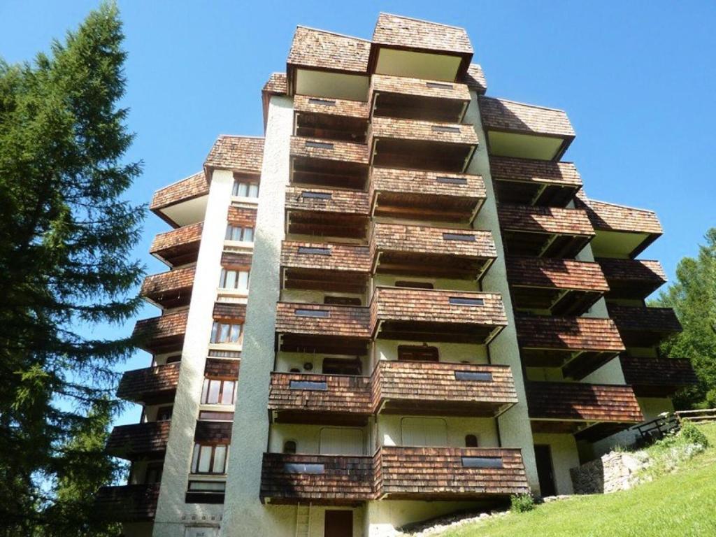 un grand bâtiment avec des balcons sur le côté dans l'établissement Résidence L'eperviere - Studio à deux pas du centre MAE-0754, aux Orres
