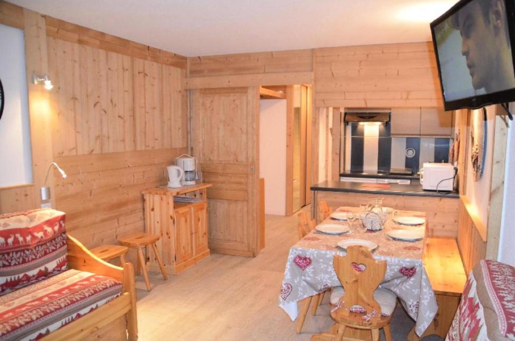 ein Esszimmer mit einem Tisch und einer Küche in der Unterkunft Résidence Chaviere - 2 Pièces pour 5 Personnes 924 in Les Menuires